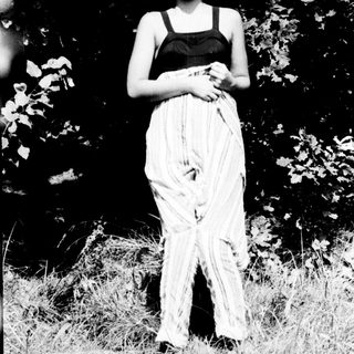Woman in black top and flowing skirt outdoors.