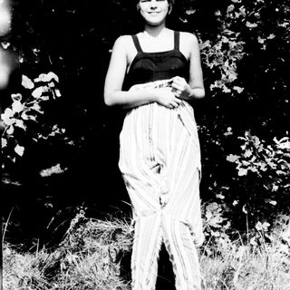 Woman in black top and flowing skirt outdoors.