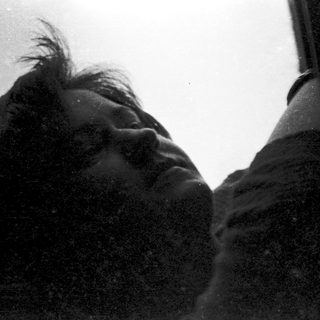 Person resting head on airplane window.