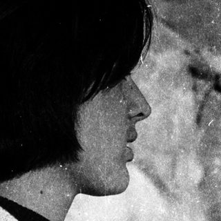 Side profile of person wearing sweater outdoors.