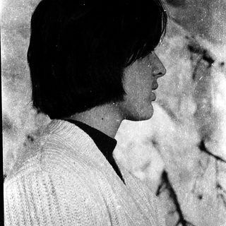 Side profile of person wearing sweater outdoors.