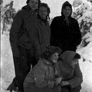 Five people dressed warmly in snowy outdoor setting.