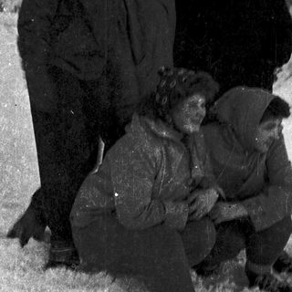 Five people dressed warmly in snowy outdoor setting.