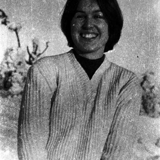 Smiling woman in traditional Japanese kimono outdoors.