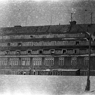 Multi-story building with visible damage and aged exterior.