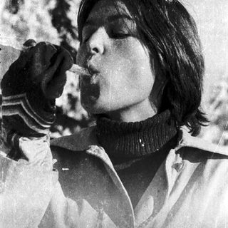 Person eating snow in winter outdoors.