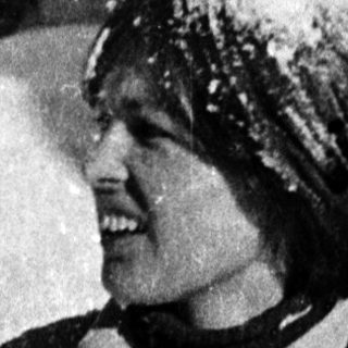 Person skiing or snowboarding happily in snowy terrain.