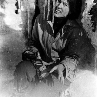 A person smiling in winter, surrounded by icicles.