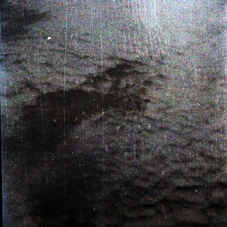Dark, rainy night scene with faintly visible trees.