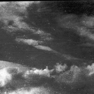 Dark sky with scattered clouds and faint stars.