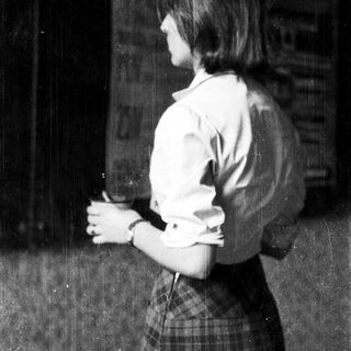 Young woman in school uniform holding cup.