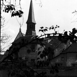 Historic church steeple with aged stone building.