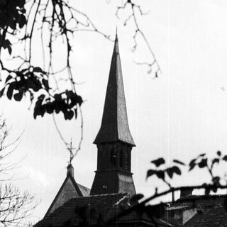Historic church steeple with aged stone building.