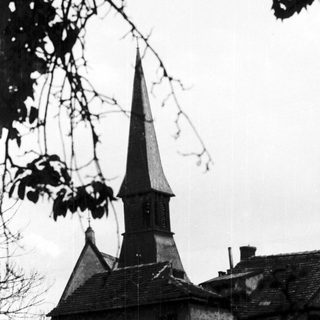 Historic stone building with pointed church steeple.