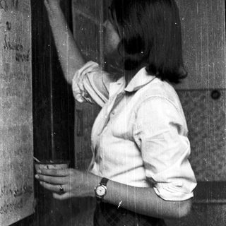 A person writing on a blackboard with chalk.