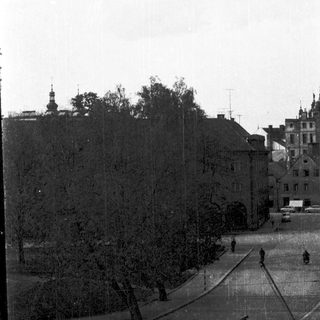 Urban street scene with historic buildings and trees.