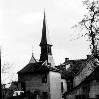 Historic church steeple with adjacent stone buildings.