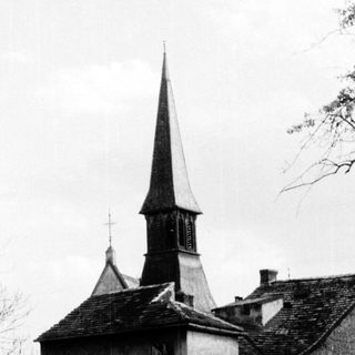 Historic church steeple with adjacent stone buildings.
