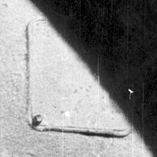 Close-up of a shoe sole on a wet, reflective surface.