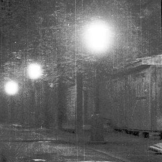 Underground tunnel with distant bright lights ahead.