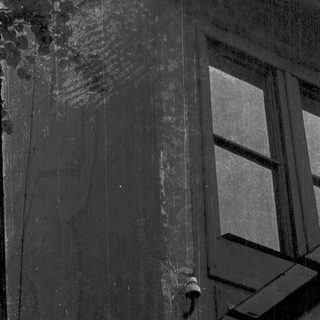 Weathered stone building facade with aged window.
