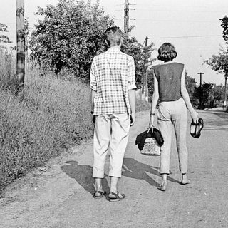 Two people walking away on a rural road.