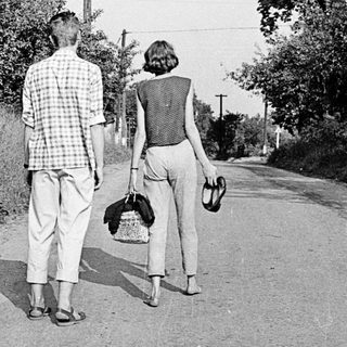 Two people walking away on a rural road.