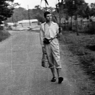 Young boy walking alone on rural road.