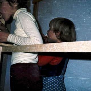 Two people eating together at a wooden table.