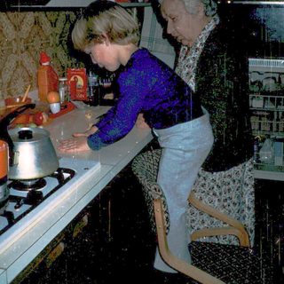 Two women cooking together in a vintage kitchen.
