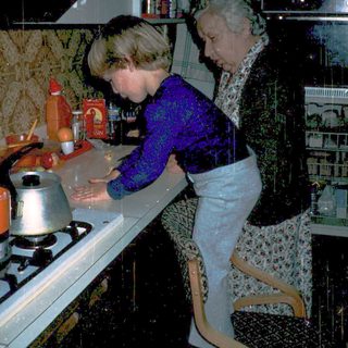 Two women cooking together in a vintage kitchen.
