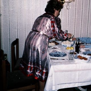 Family meal scene with woman serving children at table.