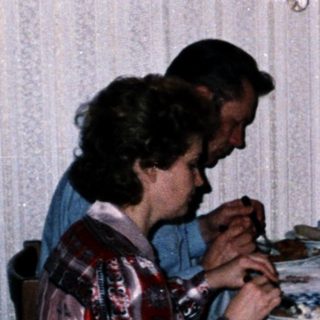 Family dining together indoors at night.