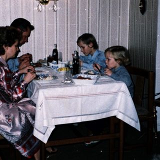 Family dining together indoors at night.