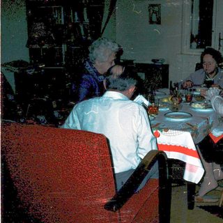 Family gathering around festive table indoors.