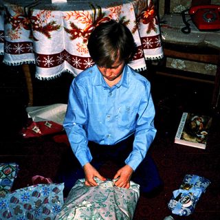Boy sewing fabric with needle and thread.