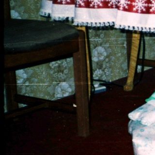 Two children opening wrapped gifts indoors.