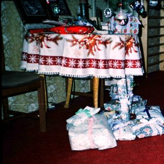 Two children opening wrapped gifts indoors.