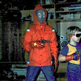 Two children dressed in futuristic, protective gear holding toy guns.