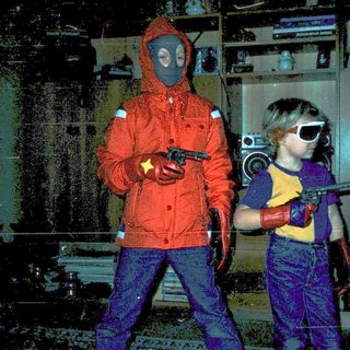 Two children dressed in futuristic, protective gear holding toy guns.