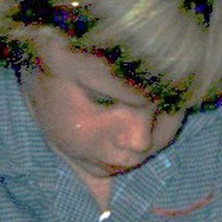Child unwrapping holiday gifts on floor.