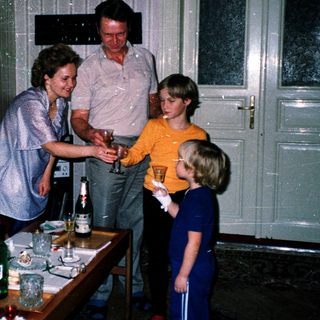 Family gathering serving drinks indoors.