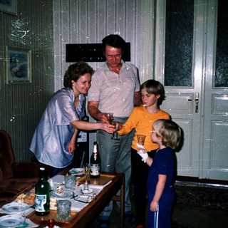 Family gathering serving drinks indoors.