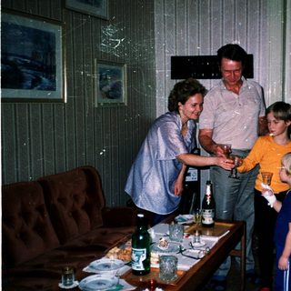 Family gathering serving drinks indoors.