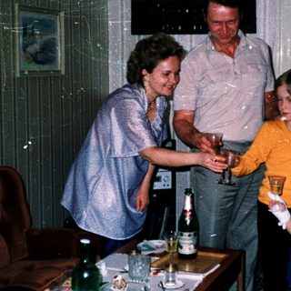 Family gathering serving drinks indoors.