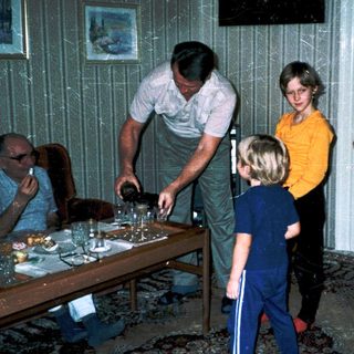 Family gathering around a table indoors.