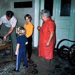 Family gathering around a table indoors.