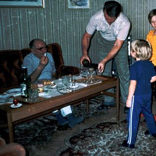Family gathering around a table indoors.