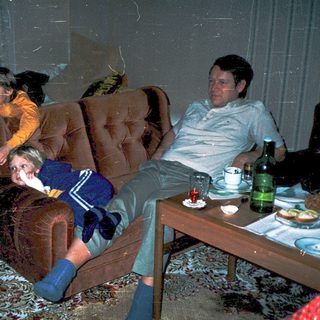 Casual indoor gathering with three people relaxing.
