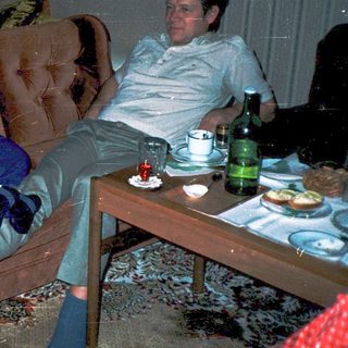Casual indoor gathering with three people relaxing.